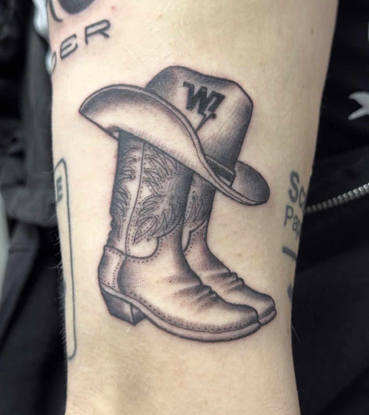 Black and grey cowboy boots with hat tattoo by Bones at Blood and Gold Tattoo Las Vegas
