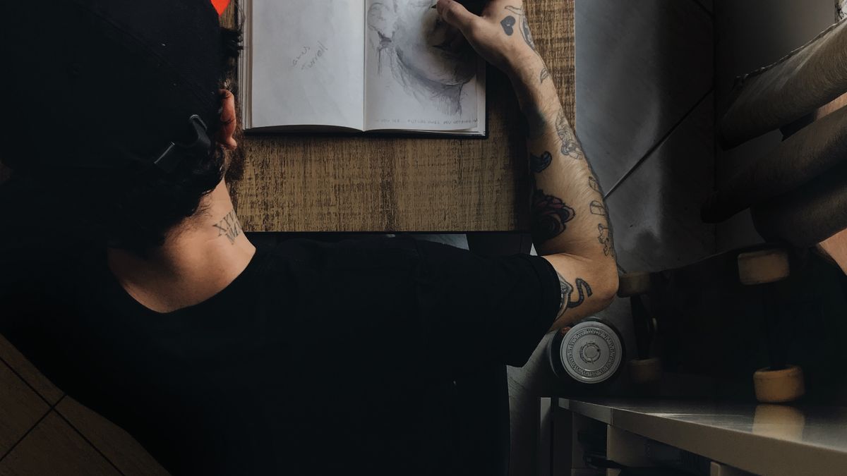 Tattoo artist sketching a design during a consultation