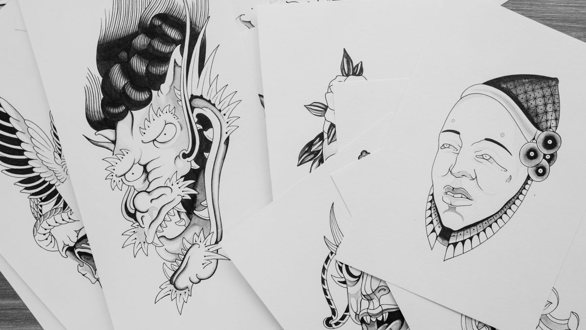Collection of black and white tattoo flash designs and sketches on paper