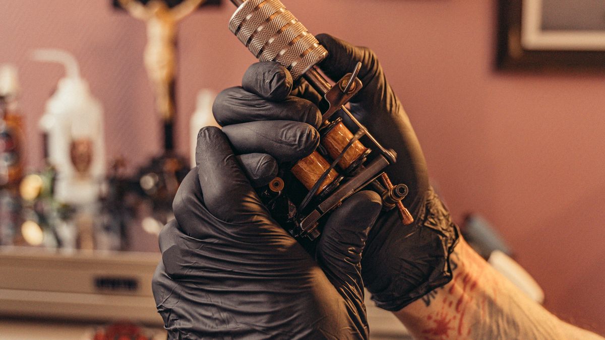 Professional tattoo machine on dark surface — tattooing equipment